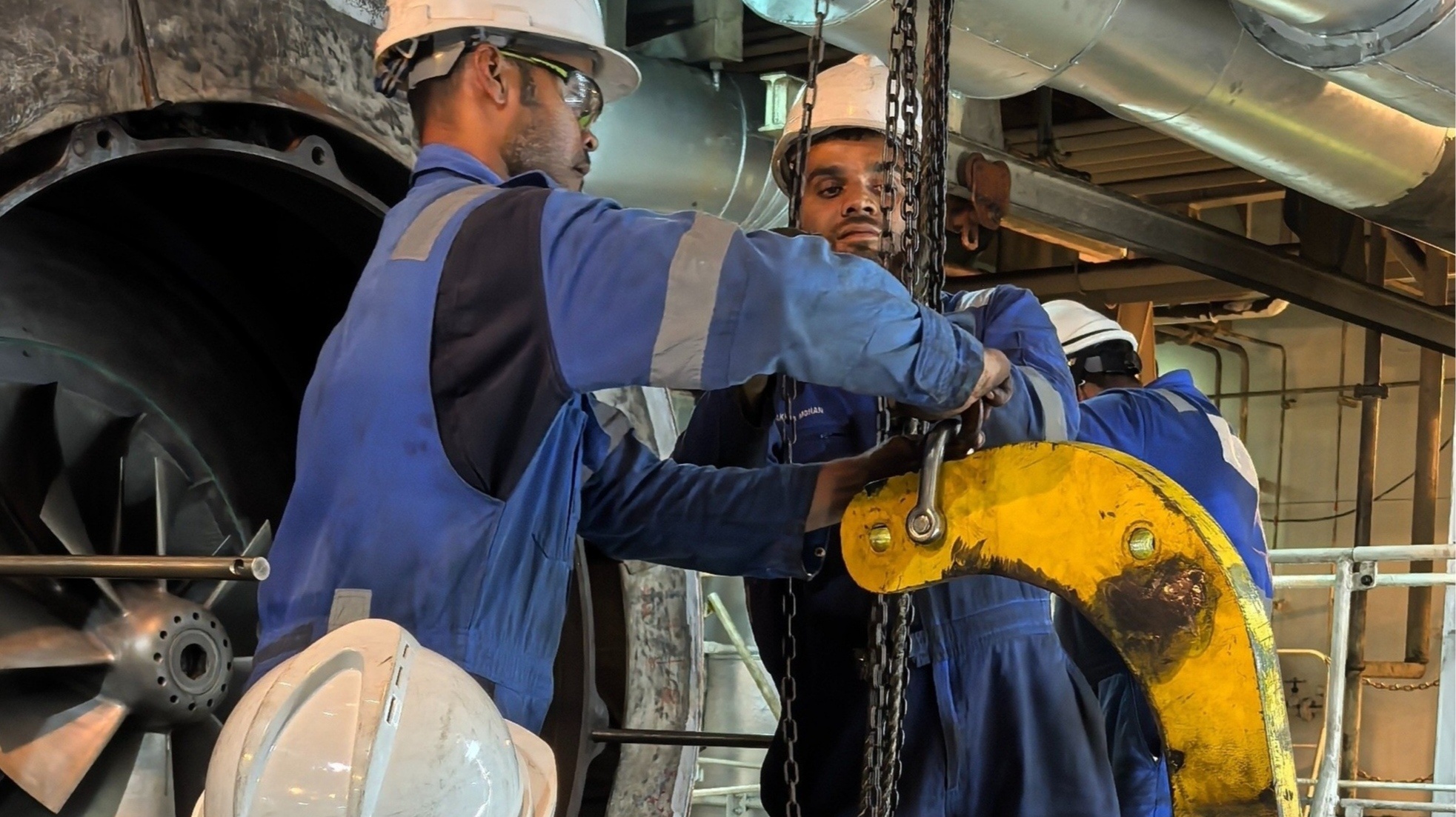 Turbocharger on a workbench with an offshore oil rig at sunset.
